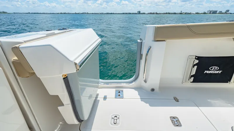Slide: The Image of Transom Door with Swim Platform Access The image showcases the transom door of the 2019 Pursuit 328, providing seamless access to the swim platform. The door features a sturdy latch system and sleek design, enhancing both functionality and aesthetics. The open door offers a glimpse of the invi - 7095031