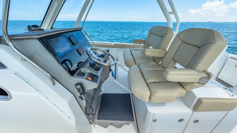 Slide: The Image of Helm Station with Dual Seating The helm station of the 2019 Pursuit 328 offers a commanding view with dual cushioned captain's chairs for ultimate comfort. The sleek dashboard is equipped with state-of-the-art navigation and control systems, ensuring a seamless journey. Enjoy panoramic - 7095036