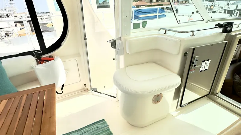 Slide: The Image of Enclosed Cockpit Seating Area This inviting enclosed cockpit of the 2006 Sea Ray 40 Motor Yacht features plush seating with a sleek, modern design. The area is adorned with a wooden table and accented with soft cushions for added comfort. Large windows offer ample natural light and a - 7150631