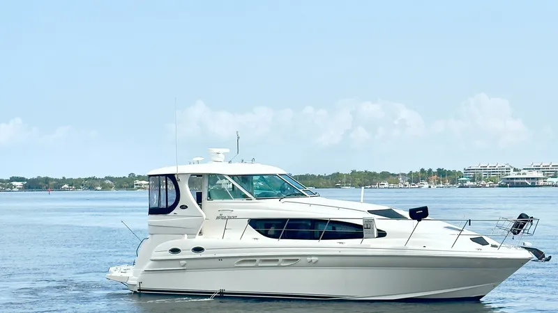 Slide: The Image of Starboard Profile of Sea Ray 40 This image showcases the sleek starboard profile of the 2006 Sea Ray 40 Motor Yacht, 'Knot on Call.' The yacht's elegant lines and spacious flybridge are highlighted against a serene water backdrop. Large windows provide ample natural light to the interio - 7150656