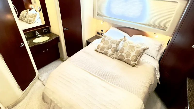Slide: The Image of Master Stateroom with Ensuite The master stateroom of the 2006 Sea Ray 40 Motor Yacht features a spacious double bed with elegant bedding and accent pillows. Rich wood cabinetry and ambient lighting create a warm, inviting atmosphere. The ensuite bathroom offers convenience and privac - 7150625