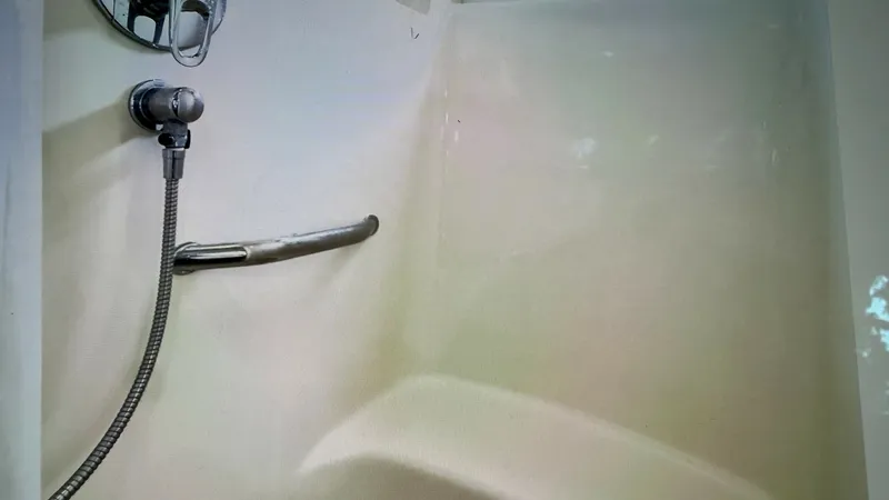 Slide: The Image of Enclosed Shower within shower bench seat This image showcases the enclosed shower area of the 2006 Sea Ray 40 Motor Yacht. The space features a clean, streamlined design with a practical handheld shower fixture and built-in grab bar for safety. The light-colored walls and ample space create an i - 7150648