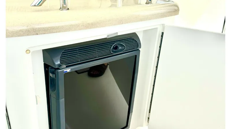 Slide: The Image of Cockpit Wet Bar with Refrigerator This image showcases the convenient cockpit wet bar of the 2006 Sea Ray 40 Motor Yacht, featuring a built-in refrigerator. The polished stainless steel railing and smooth, durable countertop add a touch of elegance and functionality. Perfect for entertain - 7150635