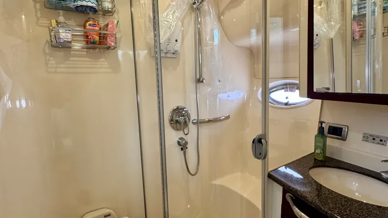 Slide: The Image of Elegant Yacht Bathroom with Shower This well-appointed yacht bathroom features a spacious shower with a glass enclosure, offering both functionality and style. The sleek countertop and integrated sink provide ample space for toiletries, complemented by a mirrored cabinet for storage. High- - 7150647