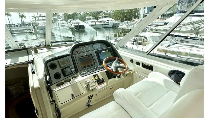 Slide: The Image of Helm Station with Luxurious Seating The helm station of the 2006 Sea Ray 40 Motor Yacht 'Knot on Call' offers a commanding view and advanced navigation equipment. Featuring a sophisticated dashboard with multiple gauges and a large central display, the helm ensures seamless control. The plu - 7150622