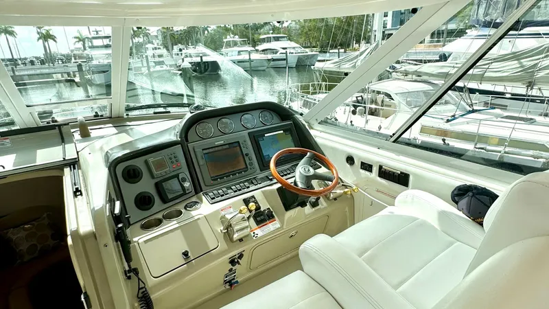 Slide: The Image of Helm Station with Plush Seating This helm station on the 2006 Sea Ray 40 Motor Yacht offers a commanding view with expansive windows and cutting-edge navigation equipment. The leather captain's chair provides comfort for long journeys, while the beautifully crafted wooden steering wheel - 7150628