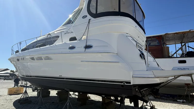 Slide: The Image of Aft View of Sea Ray 40 Motor Yacht This image showcases the sleek aft profile of the 2006 Sea Ray 40 Motor Yacht, 'Knot on Call.' The vessel is elevated on stands, highlighting its well-maintained hull and spacious aft deck. The enclosure provides protection and comfort, making it ideal fo - 7150661