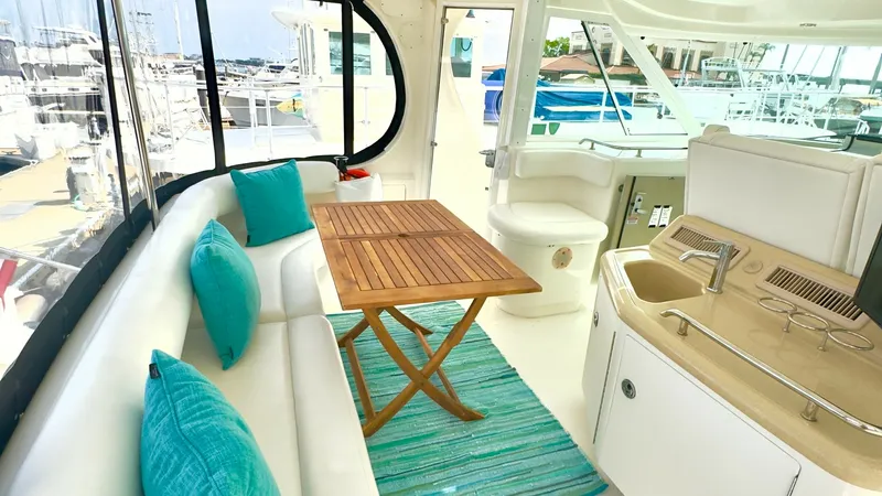 Slide: The Image of Aft Deck with Seating and Wet Bar This inviting aft deck features plush L-shaped seating adorned with vibrant teal cushions, providing a comfortable space for relaxation or dining. A stylish wooden table complements the seating area, perfect for alfresco meals. The integrated wet bar with - 7150633