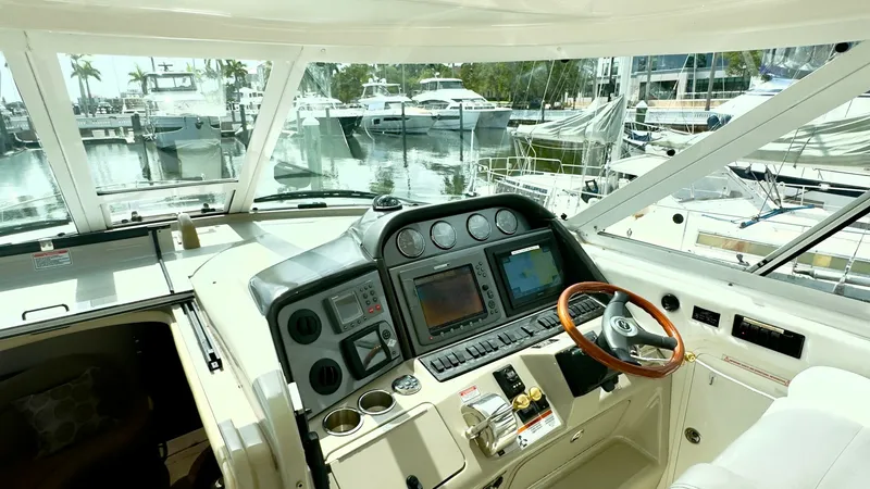 Slide: The Image of Helm Station with Electronics Display The helm station of the 2006 Sea Ray 40 Motor Yacht 'Knot on Call' showcases an array of advanced electronics, including navigation displays and control panels for seamless operation. The ergonomic design features a polished wood steering wheel and a plus - 7150636