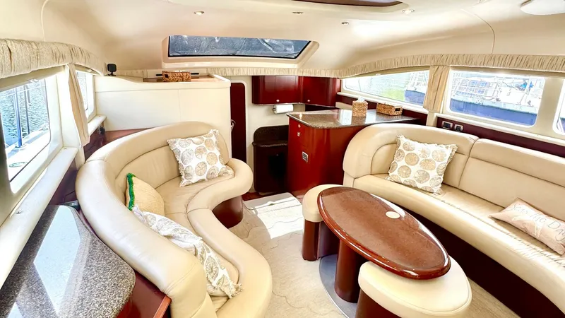 Slide: The Image of Elegant Salon with Curved Seating This inviting salon on the 2006 Sea Ray 40 Motor Yacht features plush, curved leather seating and rich wood finishes. The space is enhanced by large windows and a skylight, providing abundant natural light and stunning views. A central oval table and poli - 7150624