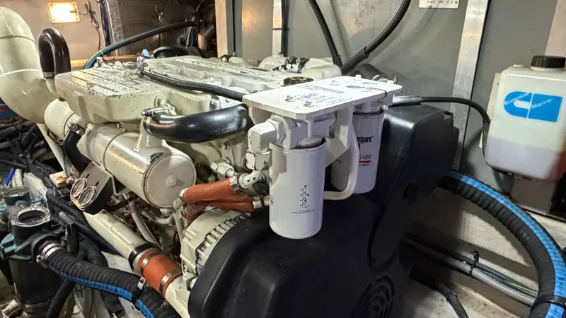 Slide: The Image of Engine Room with Diesel Engine This image showcases the engine room of the 2006 Sea Ray 40 Motor Yacht, featuring a well-maintained diesel engine. The space is clean and organized, with visible piping and filtration systems ensuring optimal performance. Ample lighting highlights the ro - 7150654