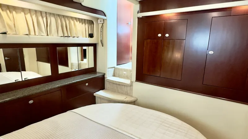 Slide: The Image of Master Stateroom with Elegant Finishes The master stateroom of the 2006 Sea Ray 40 Motor Yacht exudes comfort and sophistication. It features rich wood cabinetry and trim, providing ample storage and a warm ambiance. The plush bedding and soft lighting create an inviting and serene space for r - 7150649