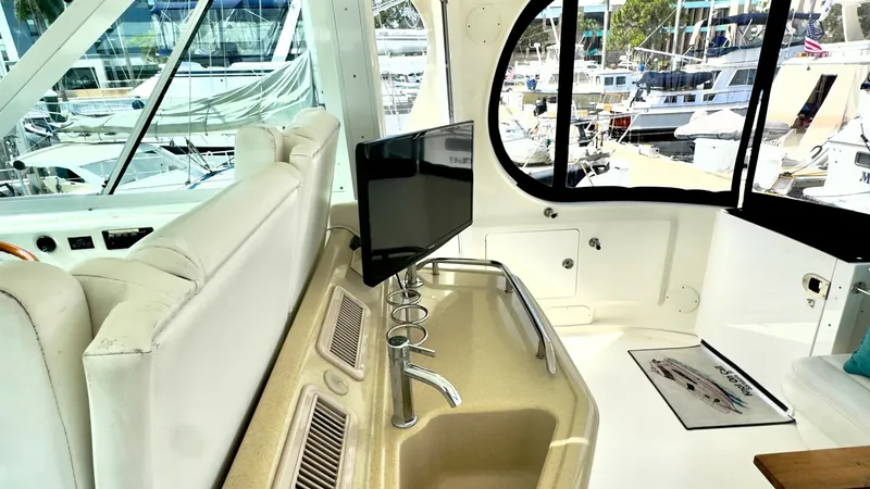 Slide: The Image of Flybridge Wet Bar Area The flybridge of the 2006 Sea Ray 40 Motor Yacht features a convenient wet bar, perfect for entertaining guests. Equipped with a sleek countertop, built-in sink, and ample storage, this area enhances the onboard experience. Large windows provide panoramic - 7150634