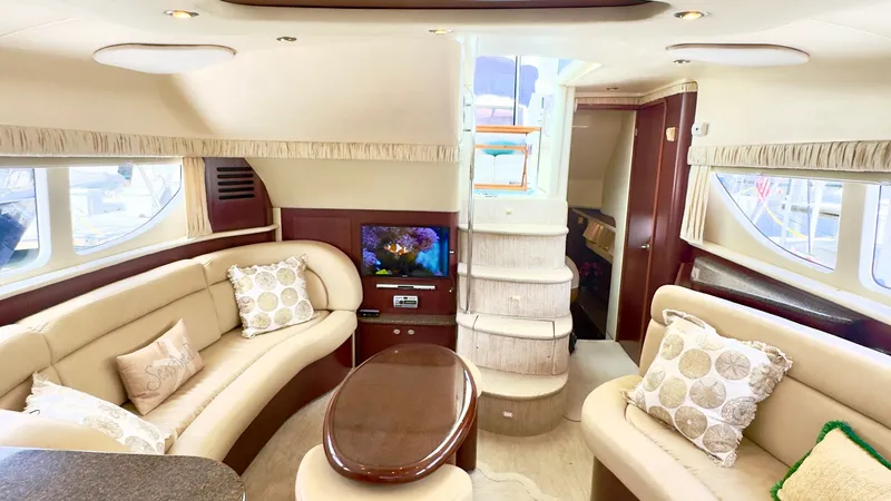Slide: The Image of Spacious Main Salon with Entertainment Center The main salon of the 2006 Sea Ray 40 Motor Yacht offers a luxurious and inviting space, featuring plush cream leather seating that wraps around the area. Large windows allow natural light to flood the interior, complemented by elegant wood finishes and s - 7150640