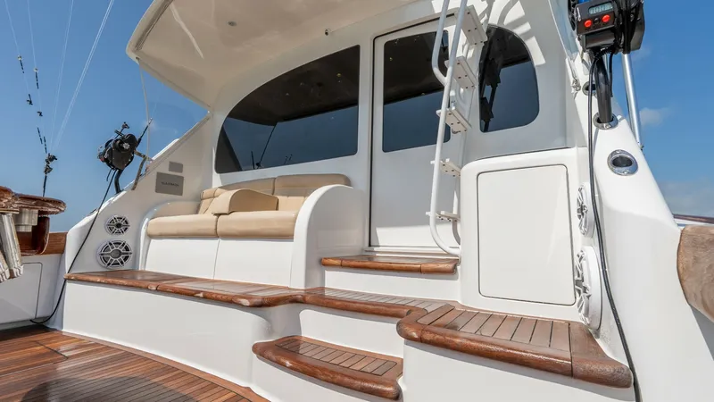 Slide: The Image of Cockpit Seating and Access Steps This image showcases the cockpit of the Viking 55 Convertible, featuring elegant teak steps and a comfortable seating area. The plush bench seat is ideal for relaxation, while the steps provide easy access to the upper deck. The clean design and quality m - 7180064