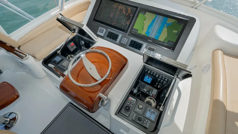 Slide: The Image of Flybridge Helm Station with Electronics The helm station on the Viking 55 Convertible showcases state-of-the-art navigation and control systems, featuring dual multifunction displays for comprehensive route mapping and monitoring. The polished wooden steering wheel and array of controls are erg - 7180046
