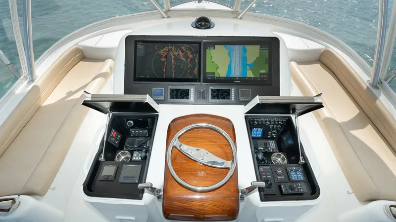 Slide: The Image of Flybridge Helm with Dual Displays The flybridge helm of the 2017 Viking 55 Convertible offers a commanding view with its dual navigational displays. The sleek, polished wood steering wheel is flanked by state-of-the-art controls housed in neatly organized panels. Comfortable seating surro - 7180050