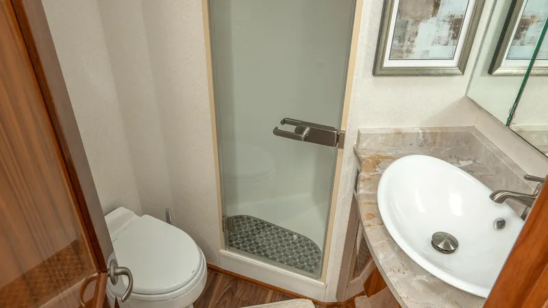Slide: The Image of Luxury Ensuite Bathroom This elegant ensuite bathroom features a sleek glass-enclosed shower and a stylish vessel sink set atop a marble countertop. The high-quality wood finishes and modern fixtures add a touch of sophistication, providing both functionality and luxury. Perfect - 7180044