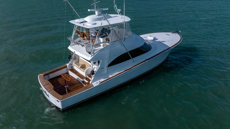 Slide: The Image of Aerial View of Aft Deck and Flybridge This stunning aerial shot showcases the Viking 55 Convertible's spacious aft deck and flybridge. The deck features exquisite teak flooring, perfect for both relaxation and fishing activities. The flybridge offers a commanding view with ample seating, maki - 7180079