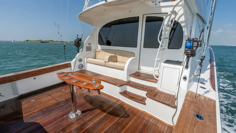 Slide: The Image of Spacious Aft Deck with Seating The aft deck of the 2017 Viking 55 Convertible showcases elegant teak flooring and a comfortable seating area, perfect for relaxation or casual gatherings. The built-in sofa offers plush cushions, while the polished table provides a convenient space for r - 7180062