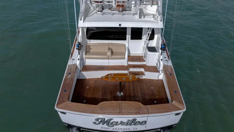 Slide: The Image of Spacious Aft Deck with Seating The aft deck of the 2017 Viking 55 Convertible 'Marilee' offers a generous space featuring elegant teak flooring and comfortable seating. Ideal for leisure or fishing, it includes a central fighting chair and built-in storage. The sleek design seamlessly - 7180083