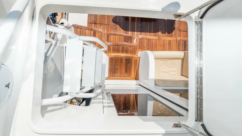 Slide: The Image of Flybridge Access and Cockpit View This image features the flybridge access of the 2017 Viking 55 Convertible, showcasing a sleek white ladder leading down to the spacious cockpit. The cockpit area is adorned with rich teak flooring and comfortable seating, perfect for relaxation or sportf - 7180057