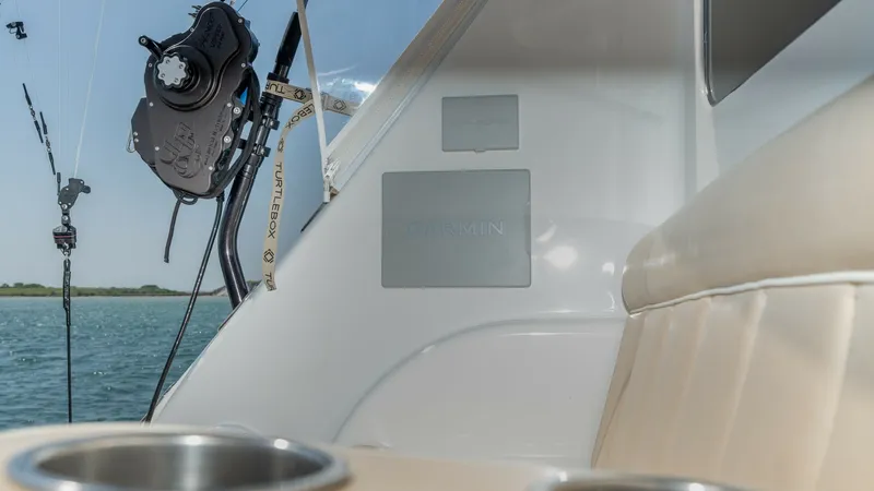 Slide: The Image of Cockpit Seating and Fishing Equipment This image showcases the cockpit area of the 2017 Viking 55 Convertible, featuring comfortable upholstered seating and integrated cup holders for convenience. The fishing setup is enhanced by high-quality equipment, including a precision reel and rod hold - 7180066