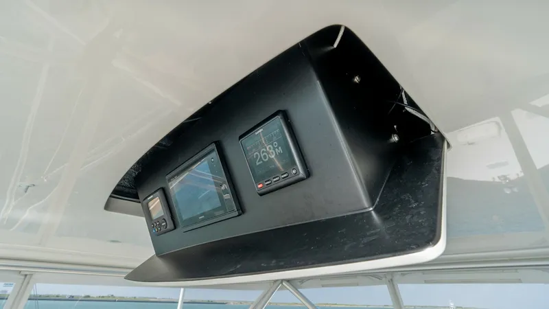 Slide: The Image of Flybridge Overhead Electronics Console The flybridge of the 2017 Viking 55 Convertible features a sleek overhead electronics console. This design provides easy access to navigation and communication systems, ensuring optimal functionality while cruising. The placement allows for a clear view o - 7180055