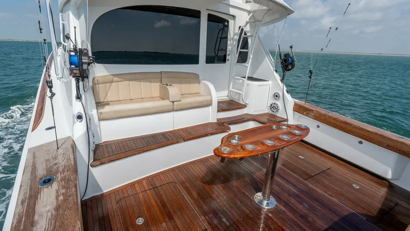 Slide: The Image of Spacious Aft Deck with Seating The aft deck of the 2017 Viking 55 Convertible, Marilee, features a luxurious teak deck offering ample space for fishing or relaxation. A plush bench seat provides comfortable seating, while the integrated rod holders and tackle station enhance the vessel - 7180063