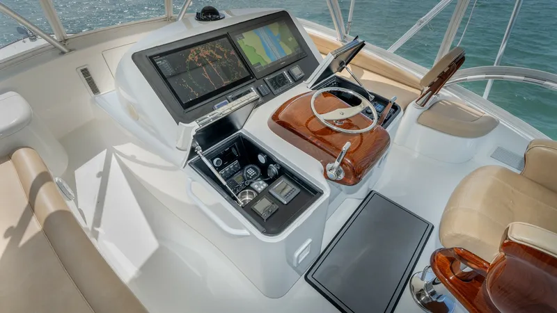 Slide: The Image of Flybridge Helm Station The flybridge helm station of the 2017 Viking 55 Convertible features a sleek, modern design with advanced navigation displays and controls. The polished wood accents and ergonomic seating provide both functionality and comfort, allowing for an optimal co - 7180047