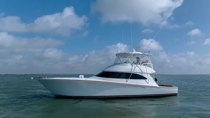 Slide: The Image of Starboard Exterior View in Open Water The 2017 Viking 55 Convertible, Marilee, showcases its sleek, modern profile against a backdrop of open water. The starboard side highlights the vessel's elegant lines and spacious flybridge, ideal for both sportfishing and leisurely cruising. With a stur - 7180081
