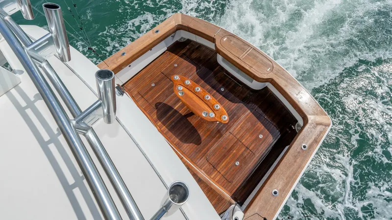 Slide: The Image of Teak Cockpit with Fishing Station The cockpit of the 2017 Viking 55 Convertible features a beautifully crafted teak deck, providing an elegant and durable finish. Central to the space is a well-equipped fishing station, perfect for avid anglers. The surrounding stainless steel railings of - 7180060