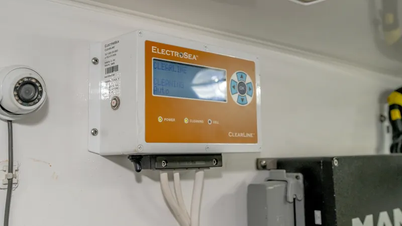 Slide: The Image of Engine Room Control Panel This image showcases the ElectroSea ClearLine system installed in the engine room of the 2017 Viking 55 Convertible. The control panel is neatly mounted, providing easy access to vital water management functions. The system is part of the advanced enginee - 7180074