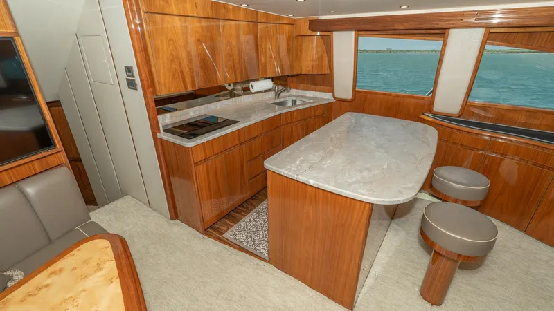 Slide: The Image of Galley with Breakfast Bar Seating The galley of the 2017 Viking 55 Convertible features elegant wood cabinetry and a sleek marble countertop. With an integrated cooktop and ample storage, this space is both functional and stylish. Large windows provide natural light and scenic views, whil - 7180032