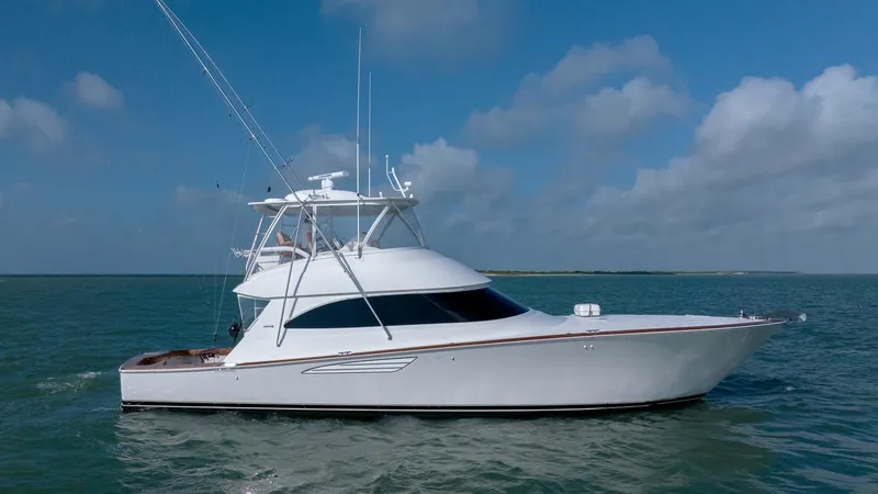 Slide: The Image of Side Profile of Viking 55 Convertible This image showcases the sleek side profile of the 2017 Viking 55 Convertible, highlighting its modern and aerodynamic design. The vessel features a pristine white hull with elegant lines, complemented by a spacious flybridge equipped with state-of-the-ar - 7180078