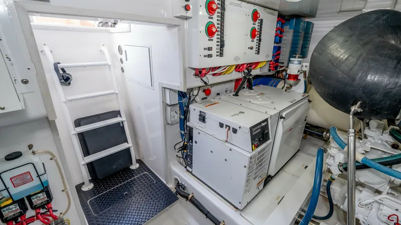 Slide: The Image of Engine Room with Generator Access This image showcases the well-organized engine room of the 2017 Viking 55 Convertible, featuring a prominently placed generator. The area is equipped with easy access ladders and well-labeled control panels, ensuring efficient operation and maintenance. T - 7180076