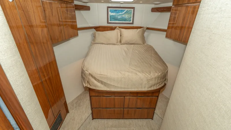 Slide: The Image of Forward Stateroom with Queen Berth The forward stateroom features a luxurious queen-sized berth, complemented by elegant wood cabinetry and soft ambient lighting. Ample storage is provided by the built-in drawers beneath the bed and overhead compartments. A skylight brightens the space, en - 7180039