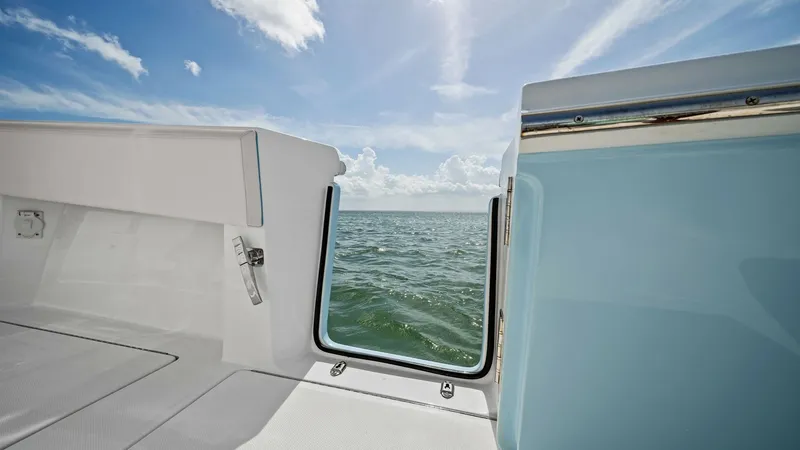 Slide: The Image of Side Door with Ocean View This image showcases the side door of the 2024 Sea Hunter 35 Tournament, offering seamless access to the water. The open door frames a stunning ocean view, highlighting the yacht's connection to the sea. The sleek design and high-quality materials ensure - 7094868