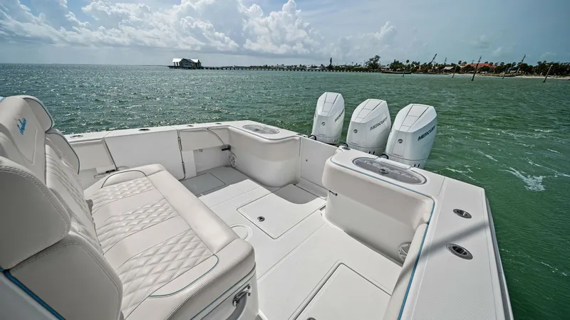 Slide: The Image of Spacious Aft Deck with Seating The 2024 Sea Hunter 35 Tournament features a spacious aft deck designed for comfort and versatility. Plush, diamond-stitched seating provides ample space for relaxation, while the robust triple outboard engines promise powerful performance. The deck's cle - 7094861