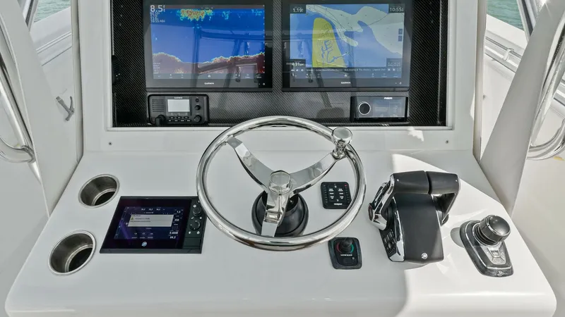 Slide: The Image of Helm Station with Dual Displays The helm station of the 2024 Sea Hunter 35 Tournament features dual high-resolution displays, providing comprehensive navigation and system control. The polished stainless-steel steering wheel is complemented by intuitive throttle and joystick controls, e - 7094863