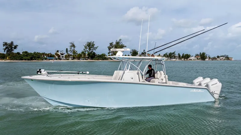 Slide: The Image of Side Profile of Sea Hunter 35 Tournament The 2024 Sea Hunter 35 Tournament is showcased cruising effortlessly through the water, highlighting its sleek hull design and powerful twin outboard engines. The center console provides ample space and visibility for navigation, while the rod holders and - 7094877