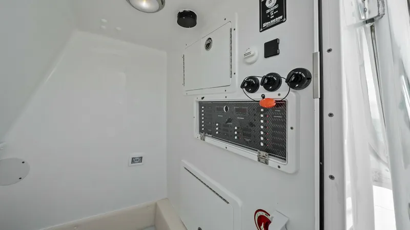 Slide: The Image of Control Panel in Interior Cabin The 2024 Sea Hunter 35 Tournament features a well-organized control panel within its interior cabin. This space is equipped with user-friendly switches and essential controls, ensuring efficient management of the vessel's systems. The clean, white finish - 7094873