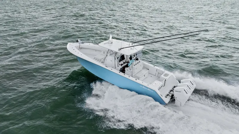 Slide: The Image of Aerial View of 35 Tournament in Action The 2024 Sea Hunter 35 Tournament slices through open waters with precision, showcasing its sleek design and powerful performance. The light blue hull stands out against the ocean, while the dual outboard engines provide impressive speed and agility. This - 7094888