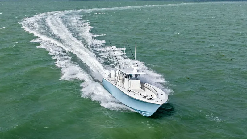 Slide: The Image of Aerial View of 35 Tournament in Motion The 2024 Sea Hunter 35 Tournament slices through the water with precision, showcasing its sleek hull design and powerful performance. The open deck layout is perfect for fishing expeditions, while the T-top provides shade and protection from the elements. - 7094889