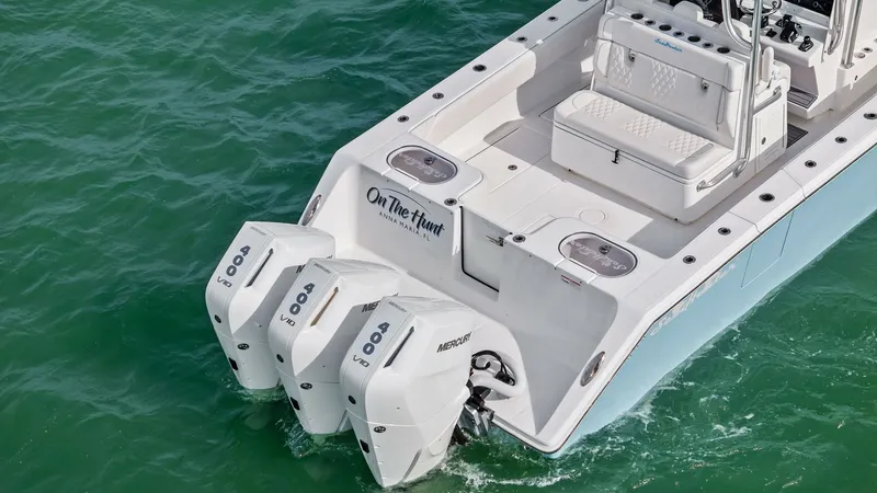 Slide: The Image of Aft Deck with Triple Engines The 2024 Sea Hunter 35 Tournament showcases a spacious aft deck equipped with triple 600 HP Mercury outboard engines, ensuring powerful performance on the water. The deck features ample seating and a clean layout, providing both comfort and functionality - 7094885