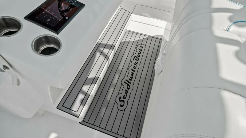 Slide: The Image of Helm Seating with Console Detail This image showcases the helm seating area of the 2024 Sea Hunter 35 Tournament. The sleek, white upholstery provides a comfortable spot for navigation, while the console features integrated cup holders and a modern touch-screen display for easy access to - 7094864