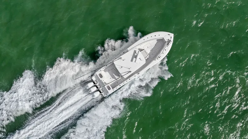 Slide: The Image of Aerial View of Sport Fishing Yacht This aerial shot captures the sleek design of the 2024 Sea Hunter 35 Tournament cruising through open waters. The image showcases the powerful triple outboard engines that provide exceptional speed and performance. The spacious deck layout is perfect for - 7094891