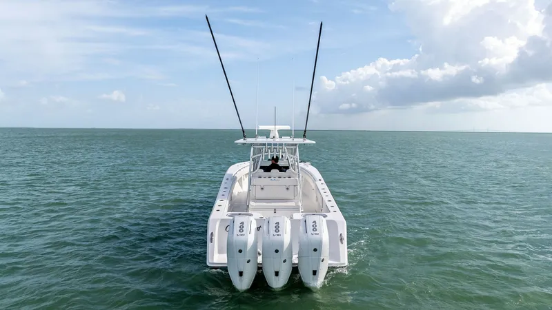 Slide: The Image of Aft View with Triple Outboards This image showcases the powerful aft section of the 2024 Sea Hunter 35 Tournament, highlighting its triple outboard engines for exceptional speed and performance. The spacious deck is designed for serious fishing enthusiasts, offering ample room for gear - 7094893