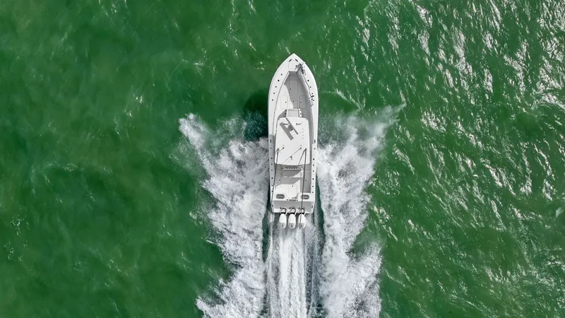 Slide: The Image of Aerial View of 2024 Sea Hunter 35 Tournament This dynamic aerial shot captures the 2024 Sea Hunter 35 Tournament slicing through vibrant waters, showcasing its impressive triple outboard engines. The clean, streamlined design is evident from above, highlighting the spacious deck layout ideal for tou - 7094890
