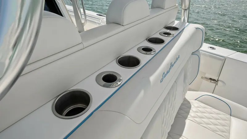 Slide: The Image of Aft Seating with Rod Holders This image showcases the aft seating area of the 2024 Sea Hunter 35 Tournament, featuring integrated rod holders for convenience. The plush, white upholstery with quilted detailing provides comfort and style, while the elegant blue accents add a touch of - 7094867